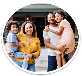 Family posing for a photo in front of a house.
