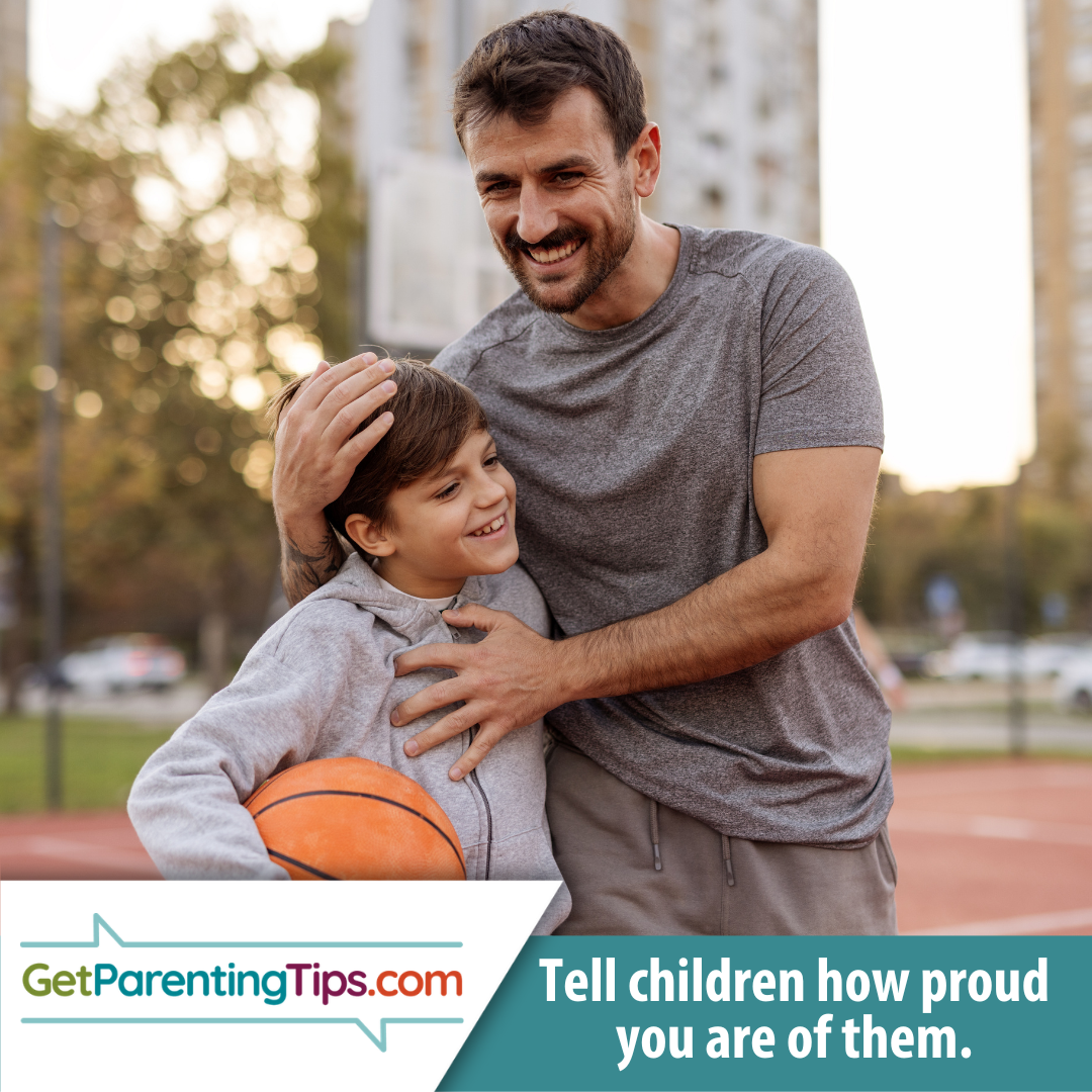 Boy is holding a basketball while his father hugs him.